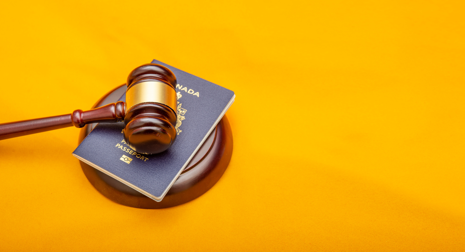 A court legal hammer on a passport and orange background images used for article on Immigration Canada IRCC